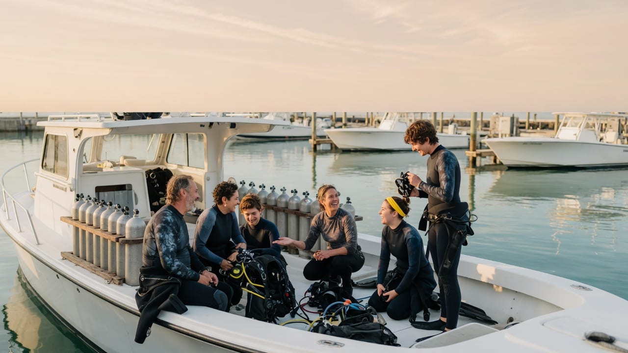 Six students and their instructor gear up on a dive boat at the dock in early morning light
